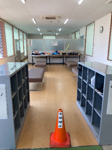 室内にベンチが複数置かれ、手前には灰色のロッカーが2つ設置されている