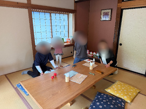 和室の部屋の中に大きなテーブルと座布団が置かれている