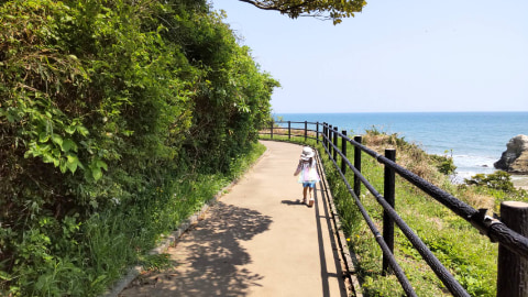 海に続く道を一人の子どもが走っている