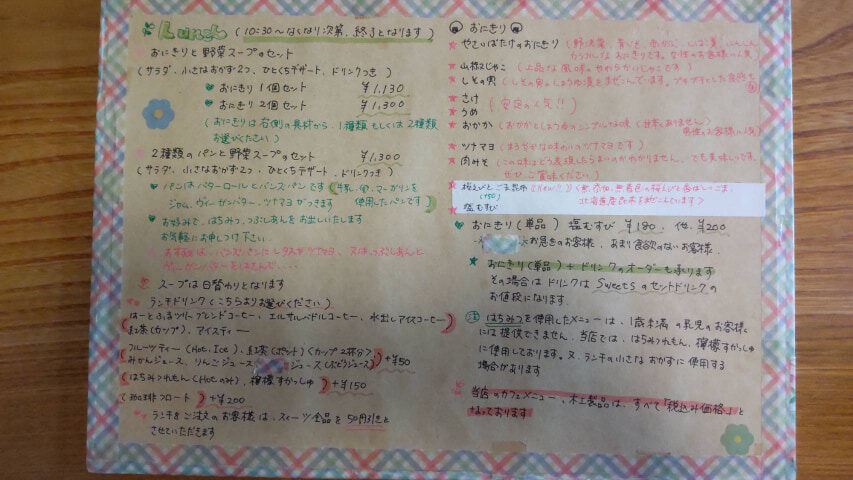 ボードにカフェのメニューが手書きで記載されている
