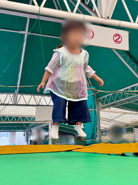 子どもがトランポリンで飛び跳ねている