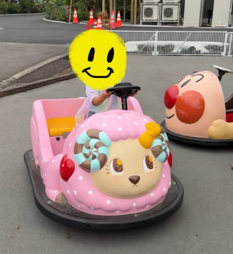 子どもがピンク色のバッテリーカーを運転して遊んでいる