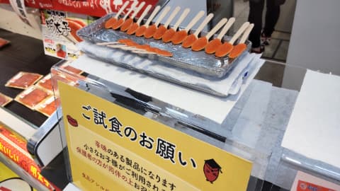 試食コーナーにめんたいこが乗ったスプーンが沢山並べられている
