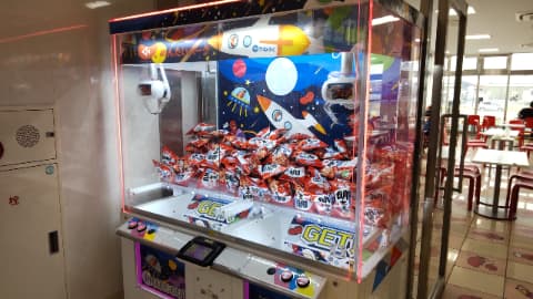 クレーンゲームの中に景品のお菓子が沢山積まれている