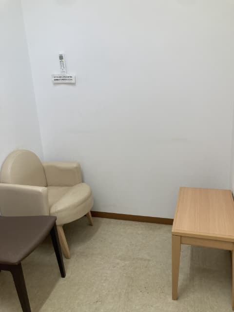 室内にテーブルと肘掛けのついたソファーチェアが置かれている