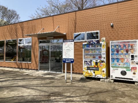 茶色い建物の前に自動販売機が設置されている
