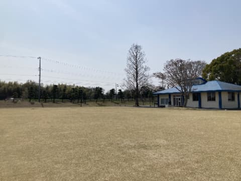 広い芝生の原っぱと青い屋根の建物