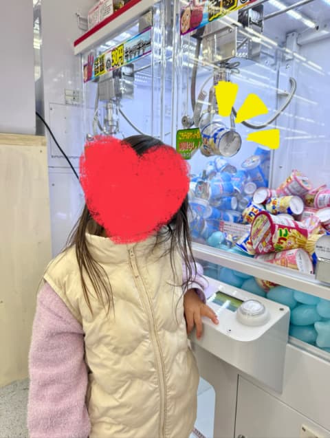 UFOキャッチャーというゲーム機の前に子どもが立っている