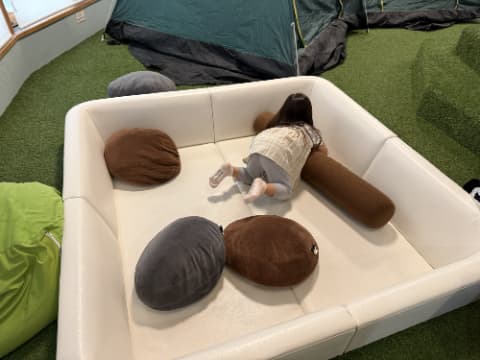 女の子がクッションマットの上で転がっている