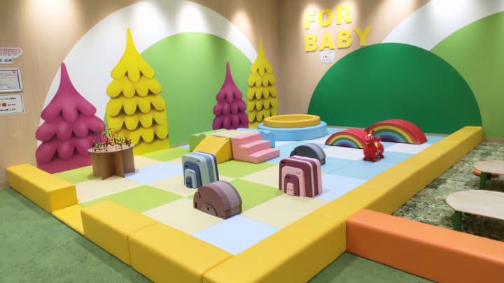 子ども用の室内遊び場にカラフルなクッションのようなものがいくつか置かれている