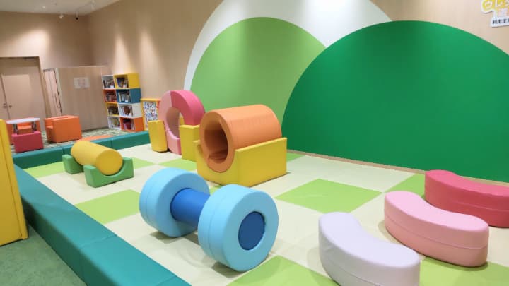 子ども用の室内遊び場にカラフルで大きな積み木のようなクッションがいくつか置かれている