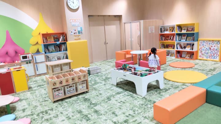 子ども用の室内遊び場にキッチンのおもちゃがあり、棚には絵本が沢山入っている
