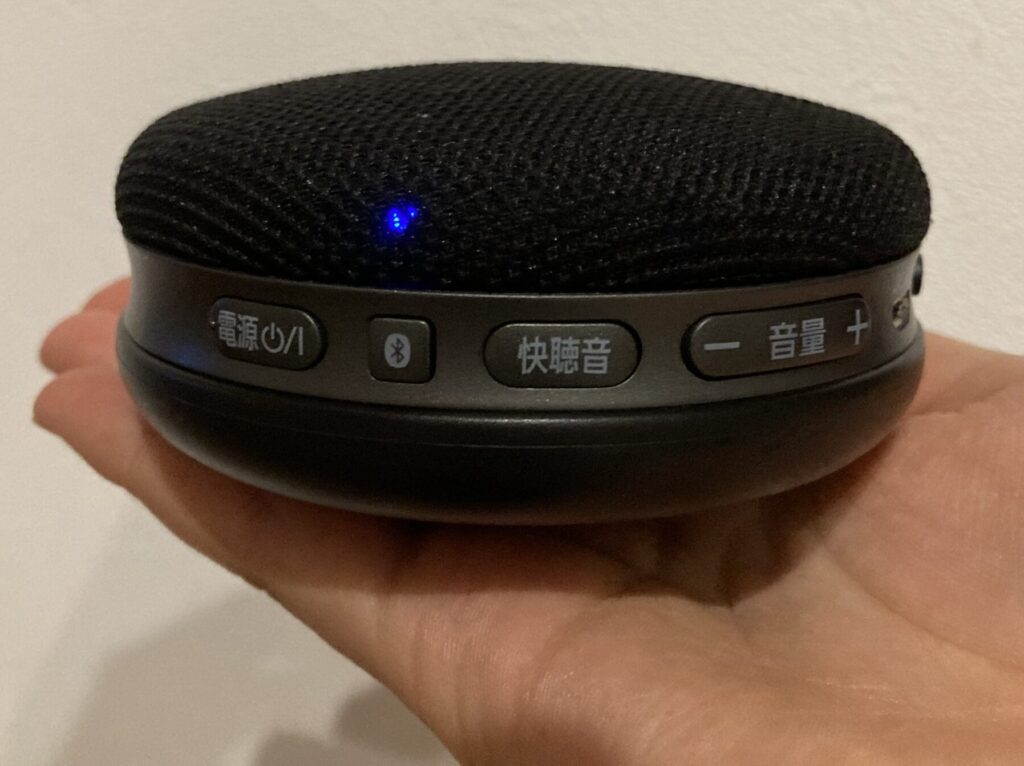 手のひらにワイヤレススピーカーが乗っている