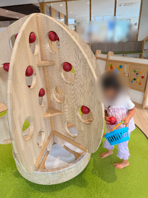 りんごの木の遊具で女の子が遊んでいる