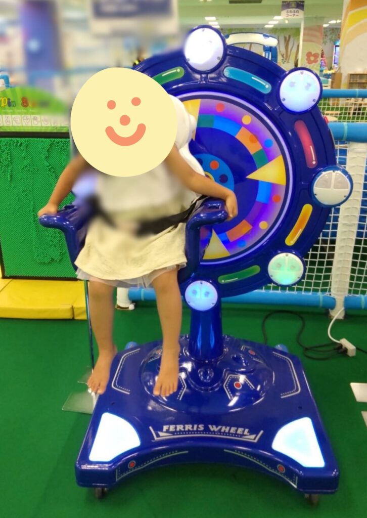 子どもが一人用の観覧車で遊んでいる
