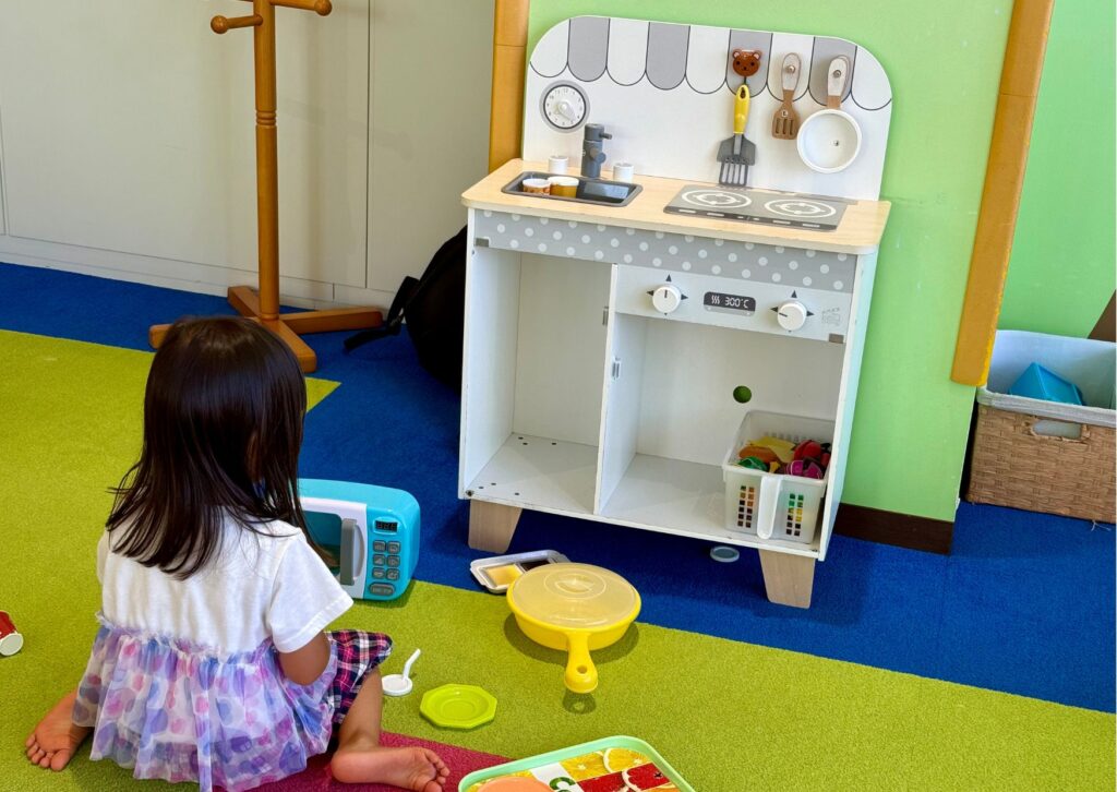 キッチンのおもちゃで小さな子供が遊んでいる