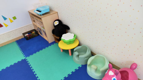 青色のマットの上に、子ども用のイスやぬいぐるみが置かれている