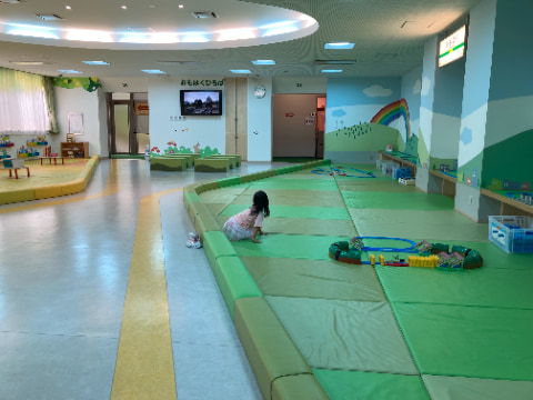 広いマット敷きの場所で子供が遊んでいる