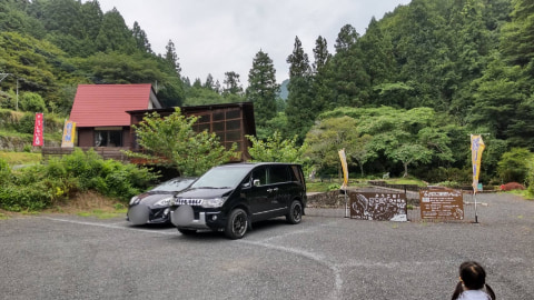 駐車場には数台の車が止まっており、その奥には建物が見える