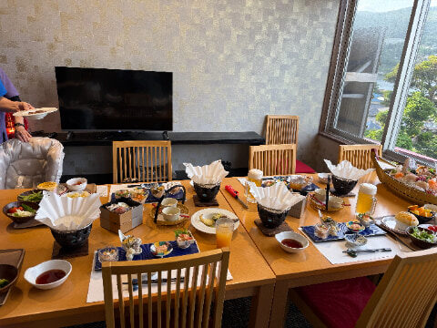 食事が置かれているテーブルの奥にはテレビが設置されている