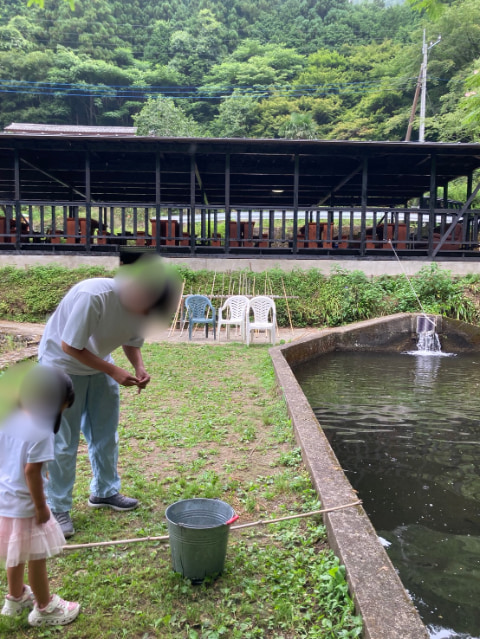 親子が釣り堀で魚釣りを始めようとしている