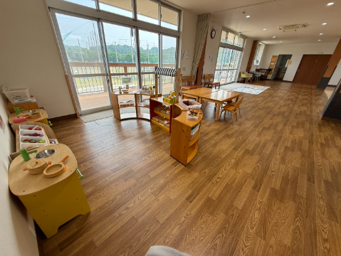 フローリングの床の上に、子ども用の遊具やおもちゃが設置されている
