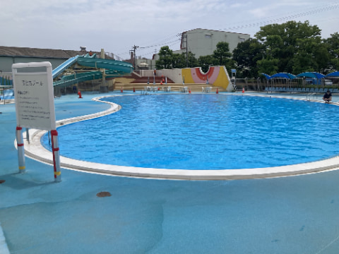 「幼児プール」と書かれた看板の後ろにプールが広がっている