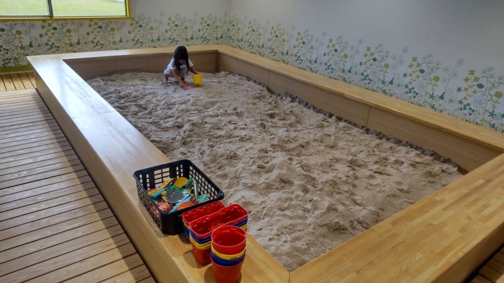 屋内のお砂場でこどもが遊んでいる